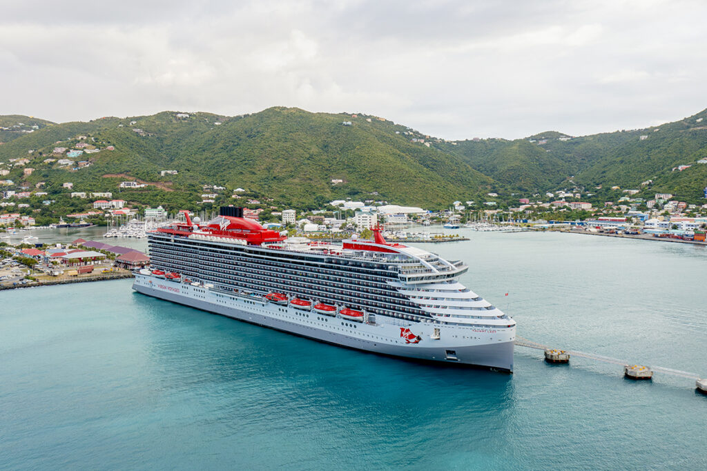 Virgin Voyages cruise ship arriving at a Caribbean destination for LoveLit Cruise guests